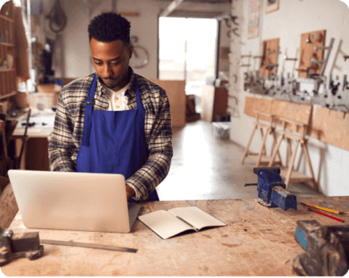 Man working on laptop in workshop