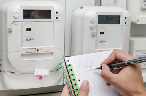 Person performing a meter reading and writing down their MPAN/ MPRN.