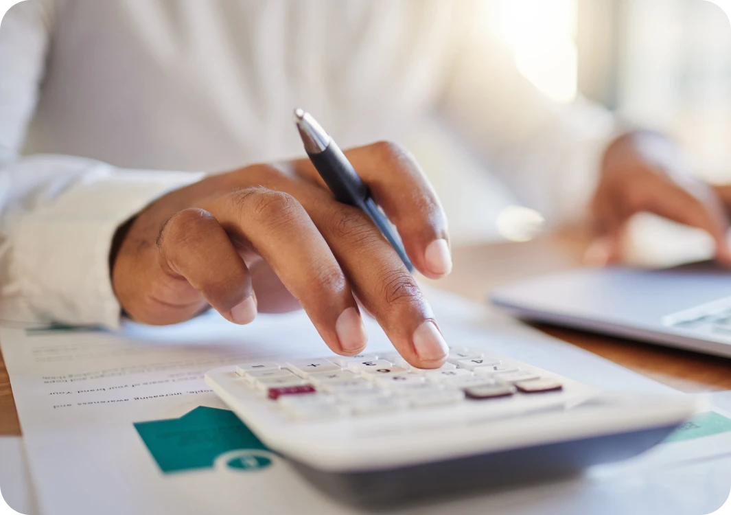 Business owner using a calculator to work out the VAT on their business electrcity bill.