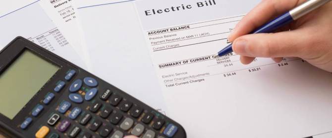 Person Calculating Standing Charges On Energy Bills